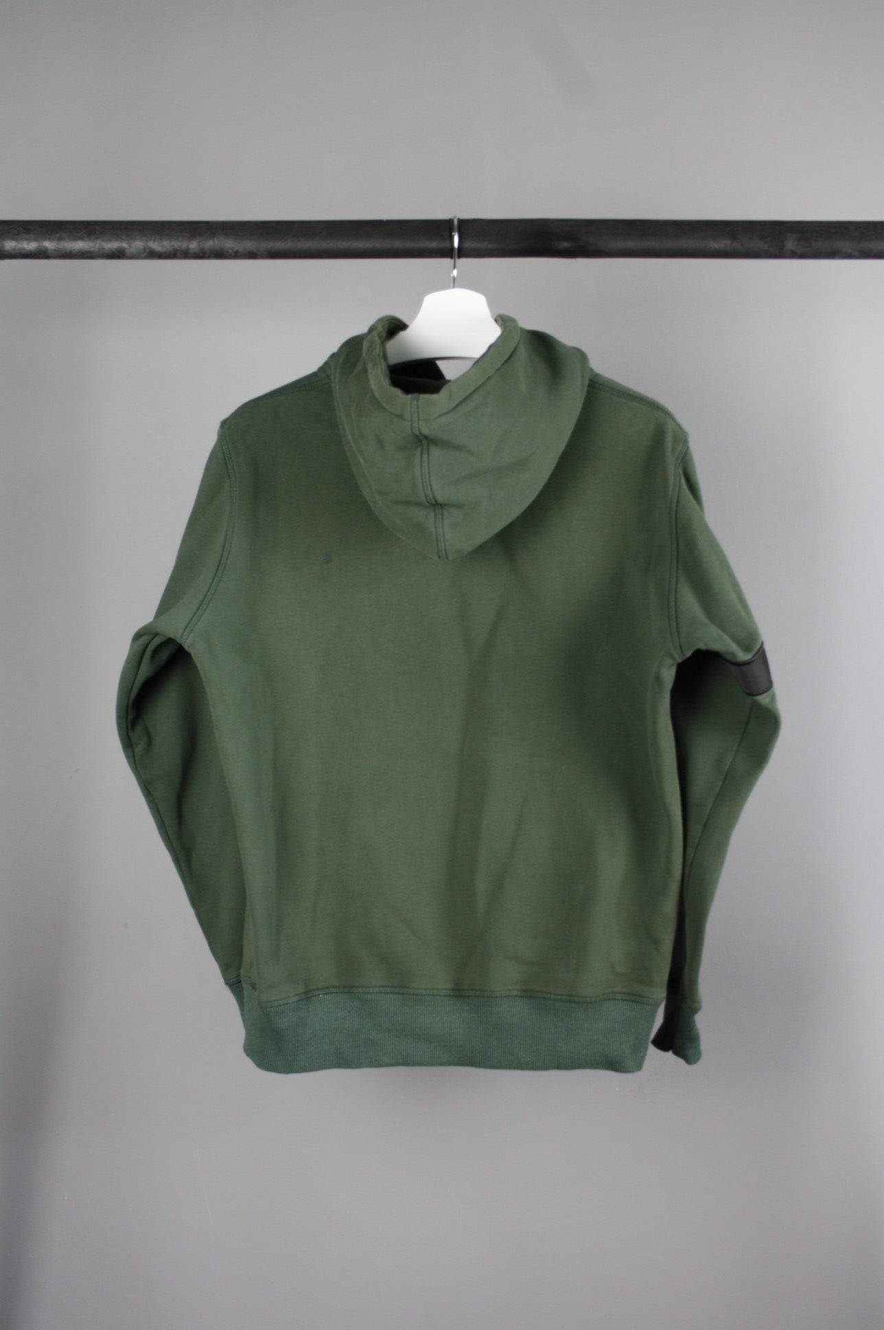 Achterkant van een groene Daily Paper Captain hoodie met een band op de rechterarm, perfect voor een trendy en casual look