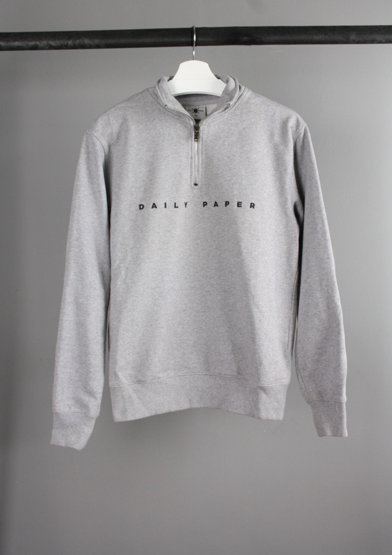 Voorkant van een grijze Daily Paper half zip sweater met een moderne snit en een ritssluiting tot aan de borst, gemaakt van comfortabele en duurzame stof