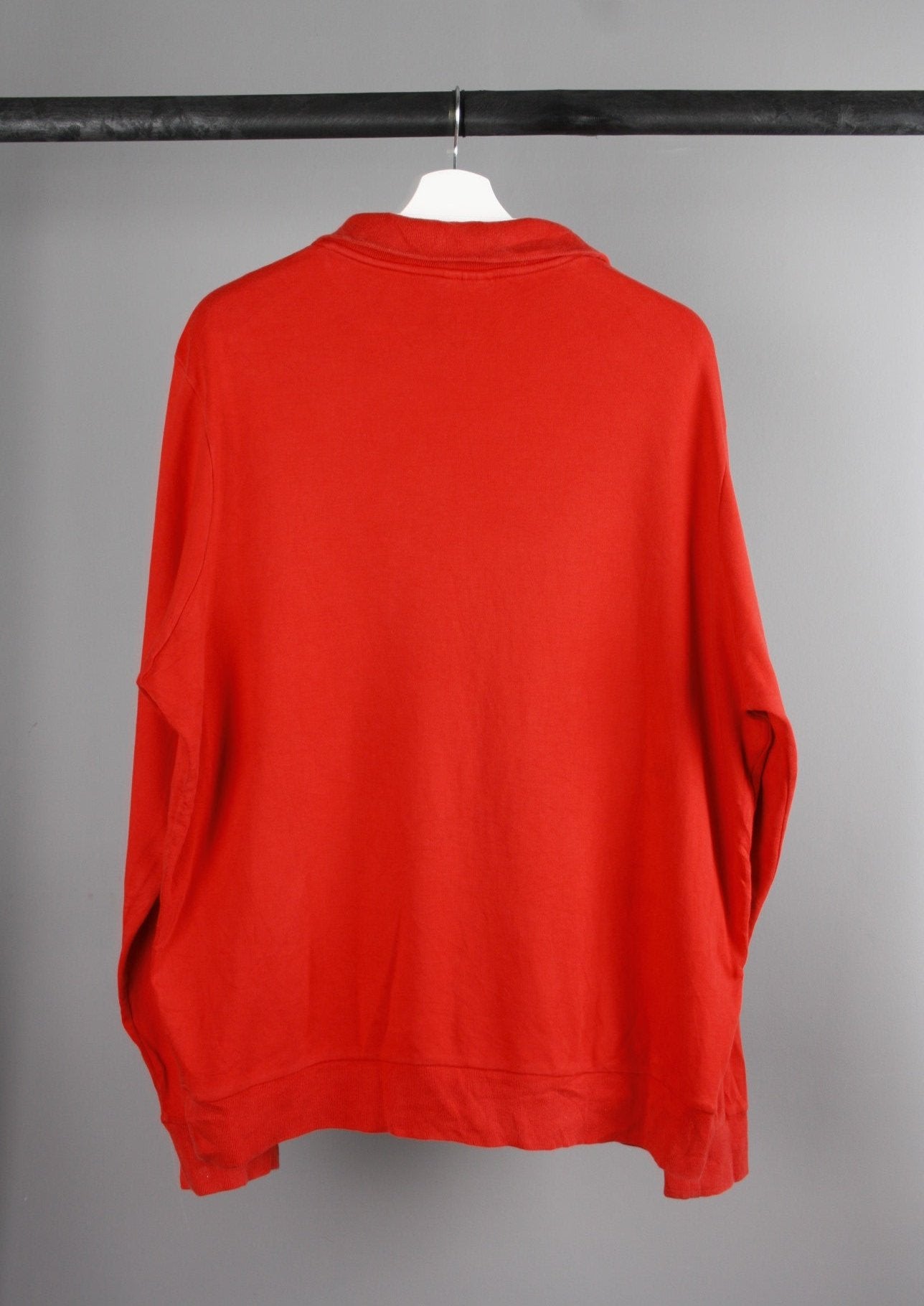 Achterkant van een rode Lacoste sweater met een eenvoudige en sportieve stijl, gemaakt van zachte katoenmix.