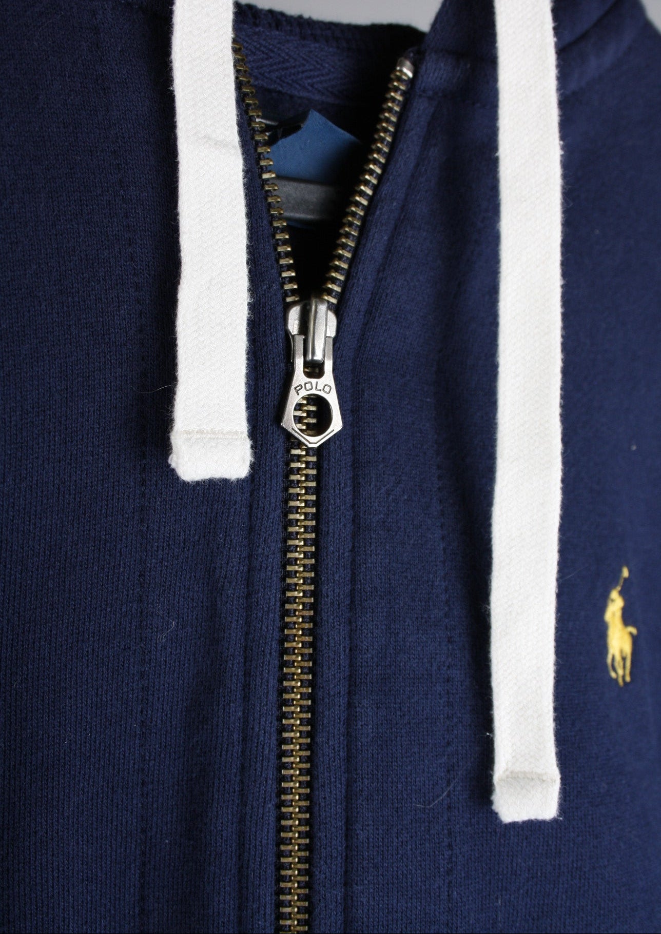 Close-up van de details van een marineblauw Ralph Lauren vest, met een fijne afwerking voor een luxe uitstraling.