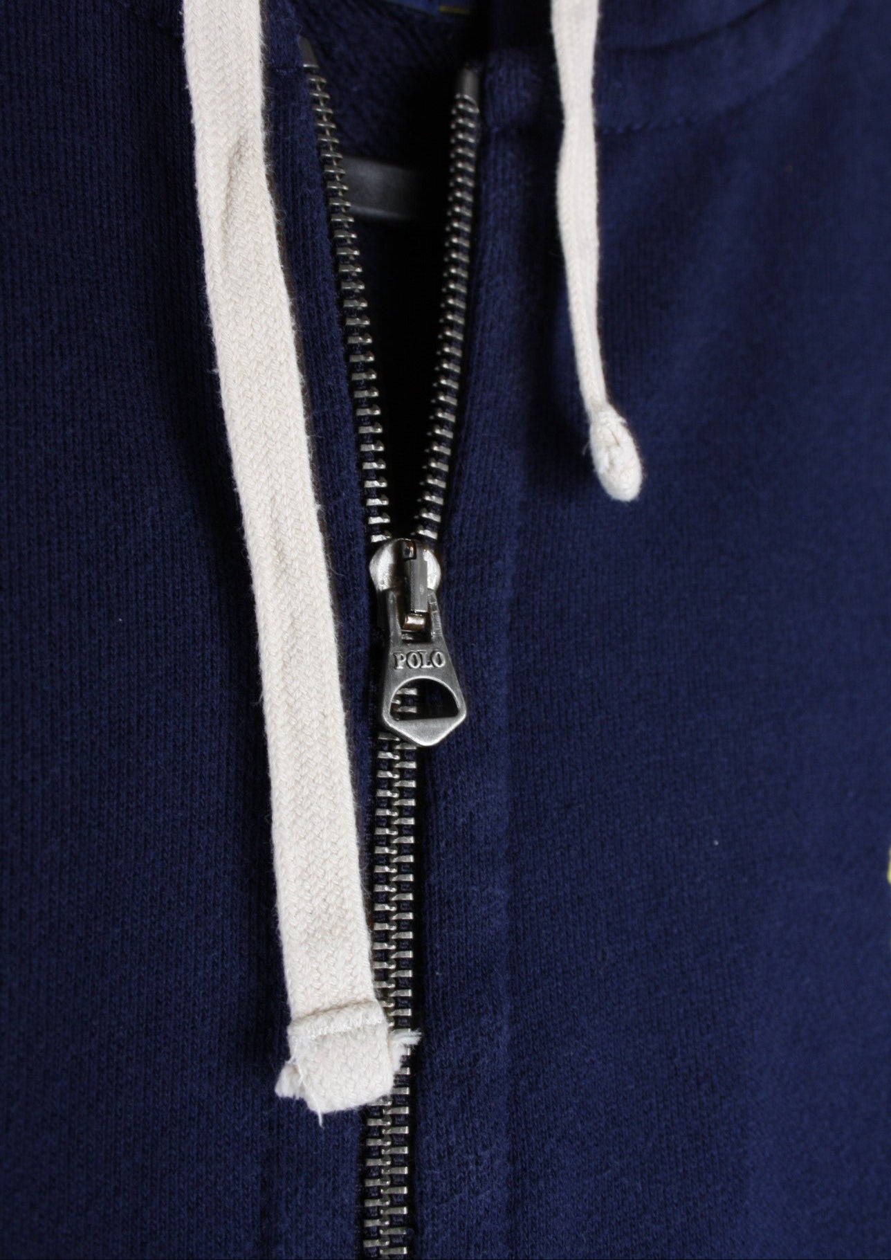 Close-up van de details van een marineblauw Ralph Lauren vest, met een fijne afwerking voor een luxe uitstraling.