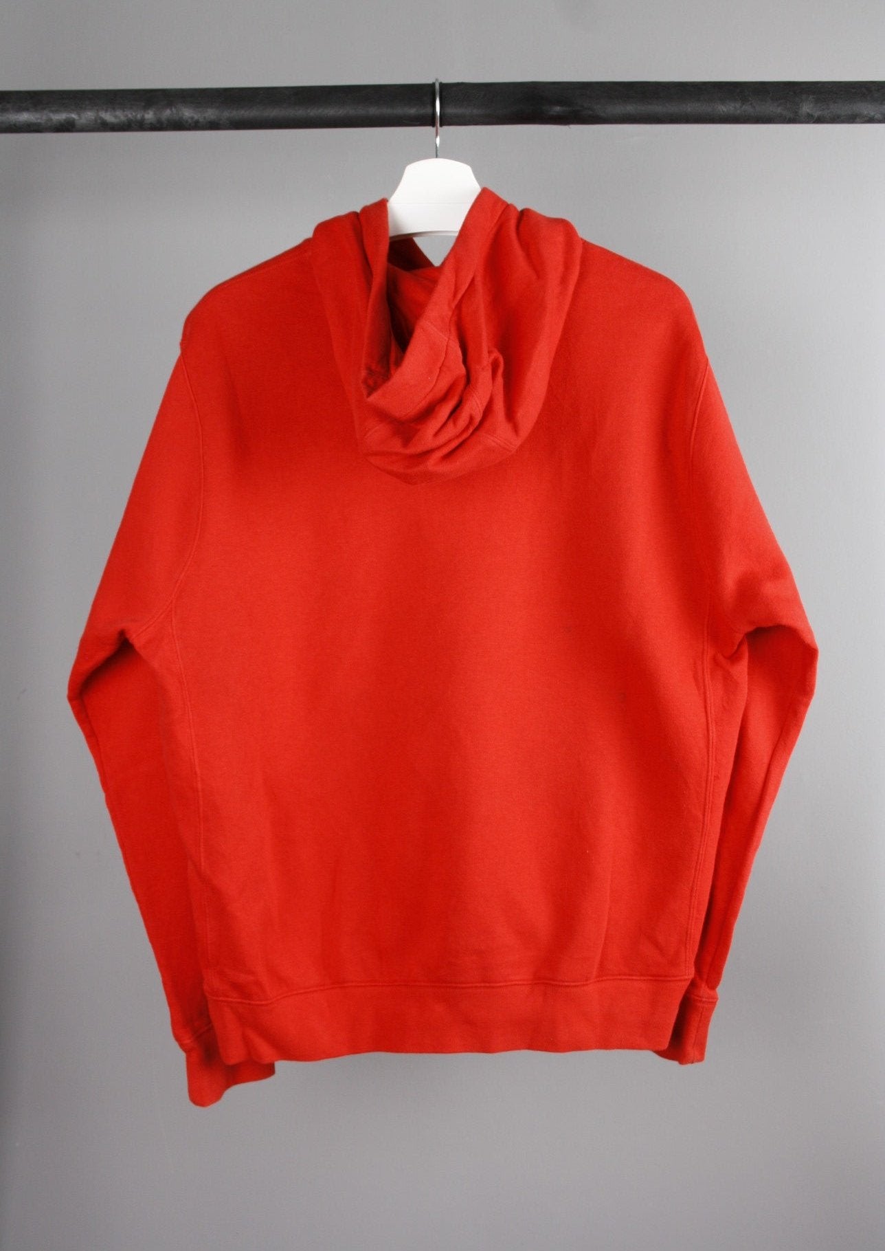 Achterkant van een rode Nike hoodie met een ontspannen pasvorm en een eenvoudige stijl, ideaal voor sportieve en casual outfits.