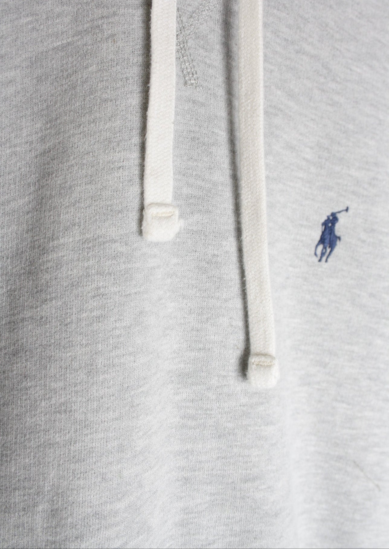 Close-up van de touwtjes van een grijze Ralph Lauren hoodie, met hoogwaardige afwerking en een stevige, stijlvolle look.