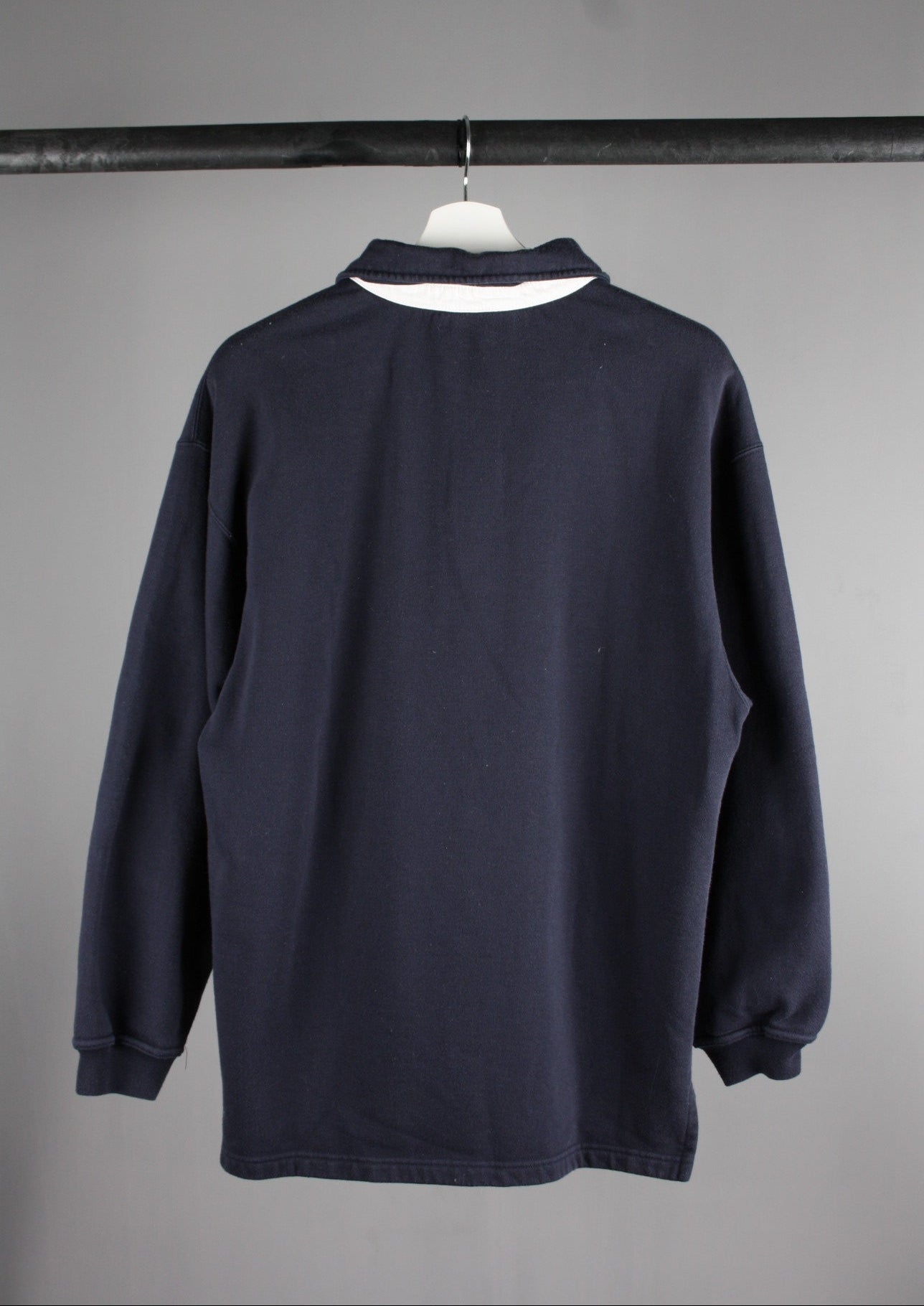 Achterkant van een marineblauwe Reebok quarter zip sweater in maat S, een comfortabele en tijdloze look voor dagelijks gebruik.