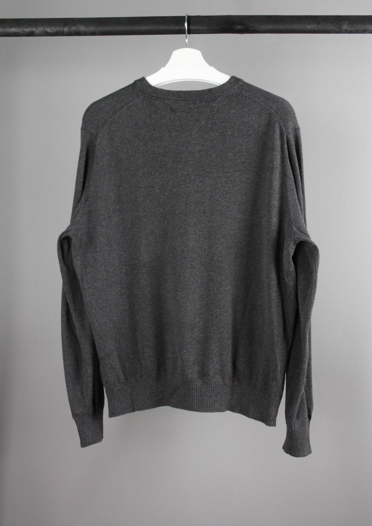 Achterkant van een grijze Tommy Hilfiger sweater met een eenvoudige en stijlvolle afwerking, ideaal voor casual en dagelijkse outfits.