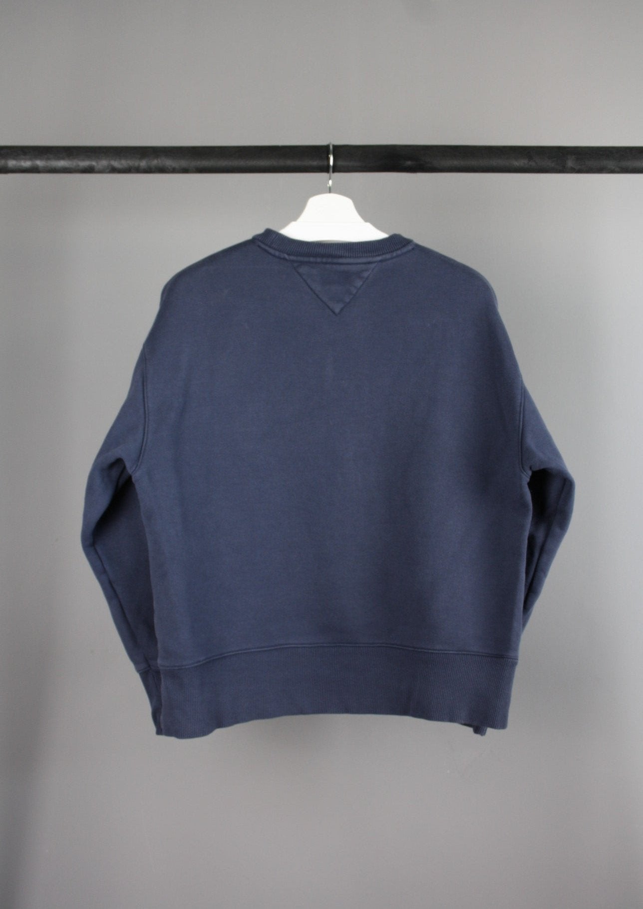 Achterkant van een marineblauwe Tommy Jeans sweater met een klassieke pasvorm, ideaal voor een casual en stijlvolle look.