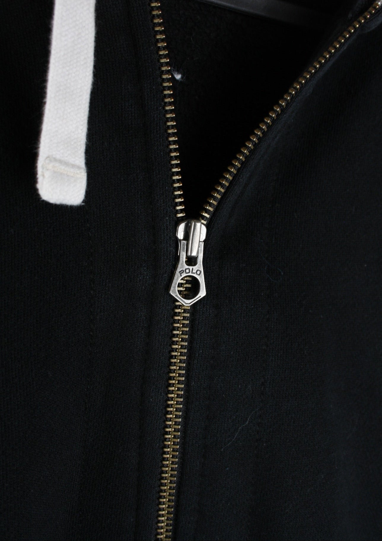 Close-up van de details van een zwart Ralph Lauren vest in maat L, met zorgvuldig afgewerkte ritsen en knopen voor een luxe uitstraling