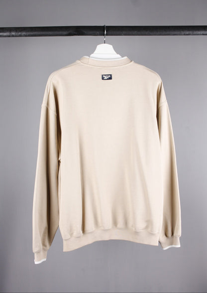 Achterkant van een beige Reebok Athletic Dept sweater in maat S, met een eenvoudige, stijlvolle pasvorm voor dagelijks comfort.