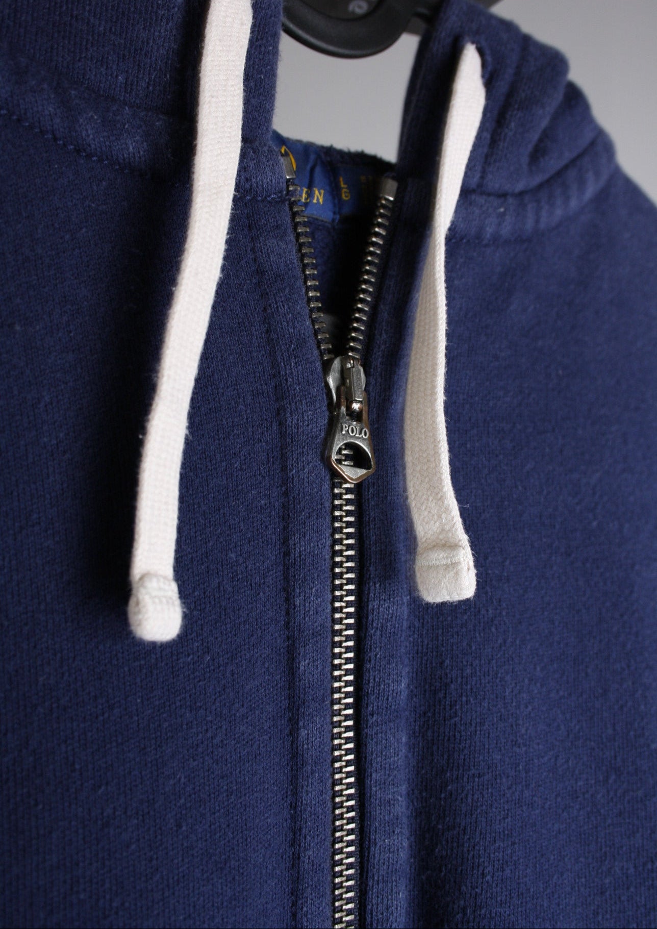 Close-up van de details van een marineblauw Ralph Lauren vest, met een verfijnde afwerking en een luxe uitstraling.