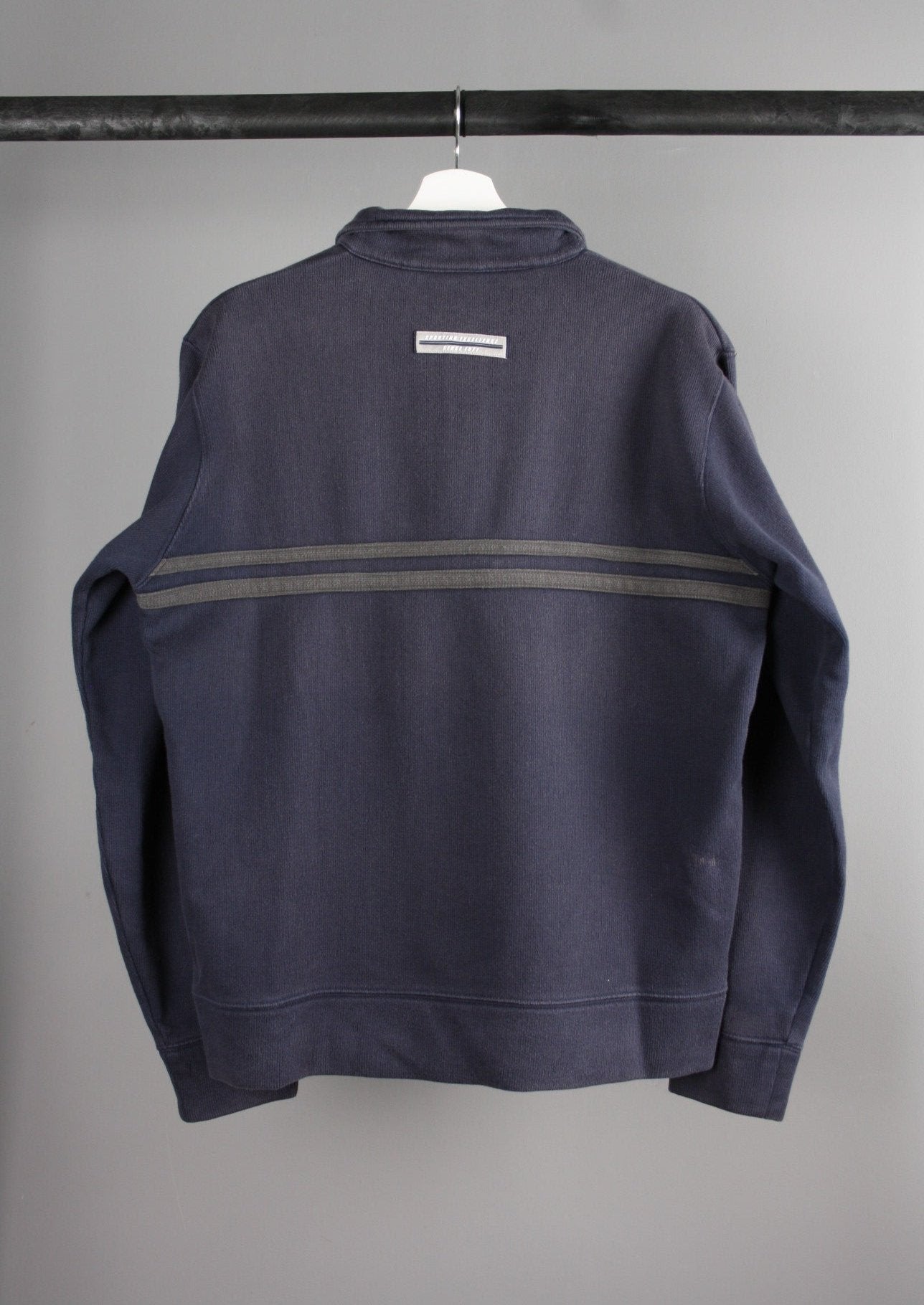Achterkant van een marineblauwe Nike quarter-zip sweater met een vintage look, met een eenvoudige en stijlvolle afwerking, ideaal voor een retro-geïnspireerde look.