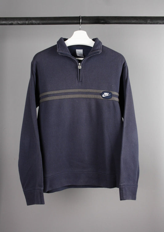 Voorkant van een marineblauwe Nike quarter-zip sweater met vintage uitstraling, voorzien van het klassieke Nike Swoosh-logo op de borst en een opstaande kraag.