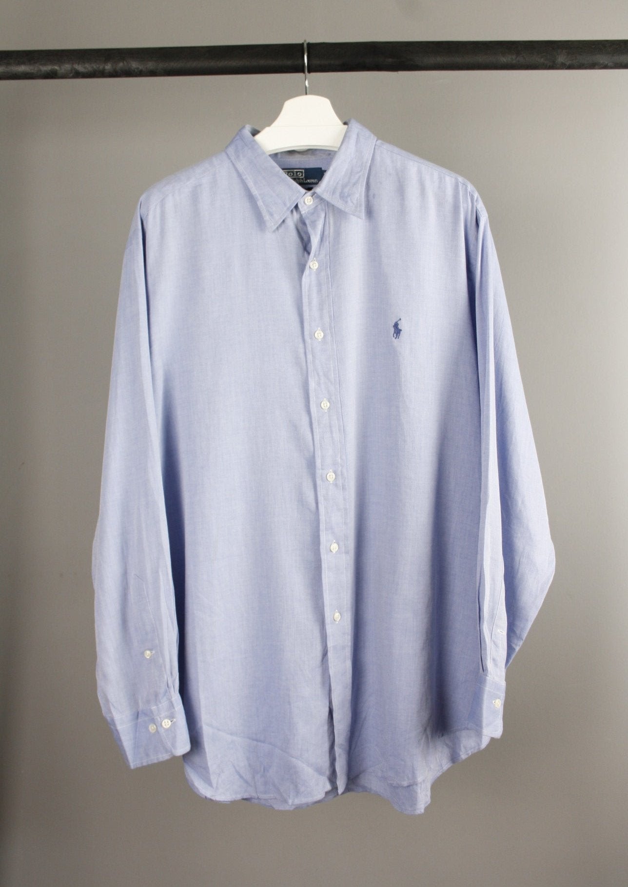 Voorkant van een lichtblauwe Ralph Lauren blouse met een marineblauw geborduurd paardje op de borst, gemaakt van zachte katoenen stof voor een klassieke uitstraling.