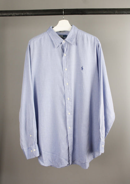 Voorkant van een lichtblauwe Ralph Lauren blouse met een marineblauw geborduurd paardje op de borst, gemaakt van zachte katoenen stof voor een klassieke uitstraling.