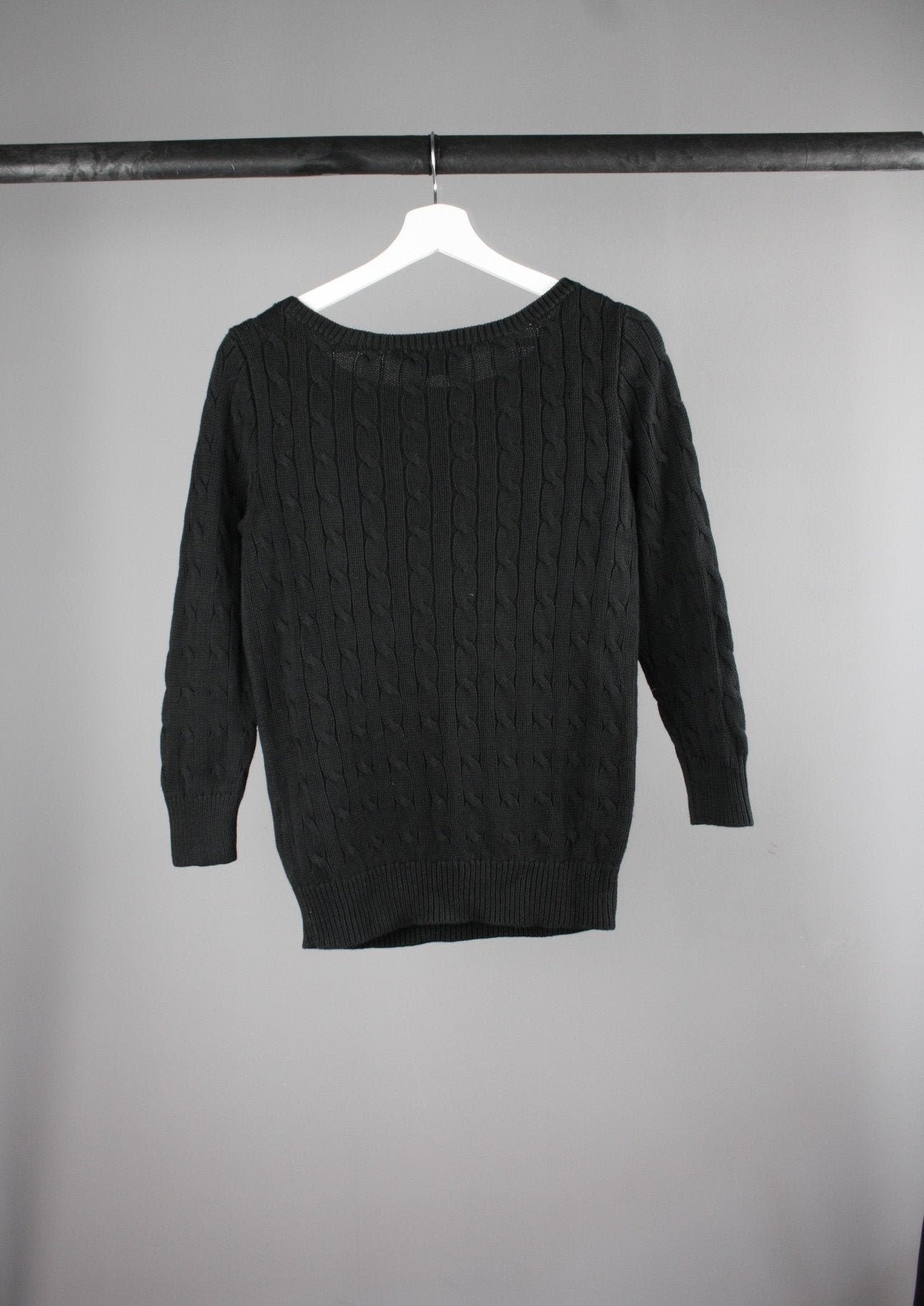Achterkant van een zwarte Ralph Lauren cable knit sweater met een subtiel wit logo op de borst, perfect voor een tijdloze en verfijnde look.