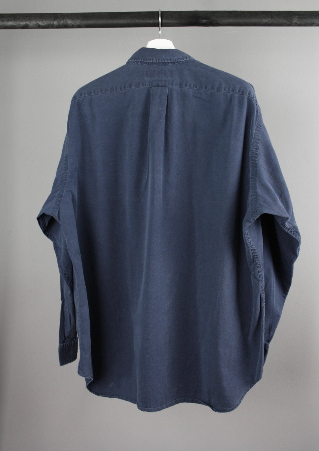 Achterkant van een marineblauw Ralph Lauren overhemd met een eenvoudig ontwerp en een rood paardje op de voorkant, ideaal voor een elegante en casual look.