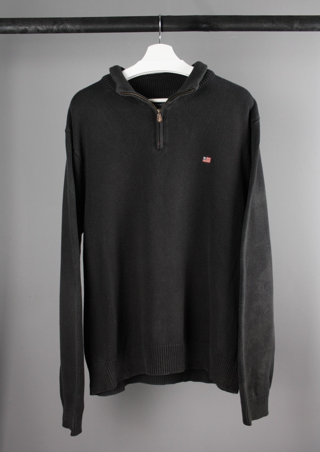 Voorkant van een zwarte Ralph Lauren quarter-zip sweater met opstaande kraag en subtiel geborduurd logo op de borst.
