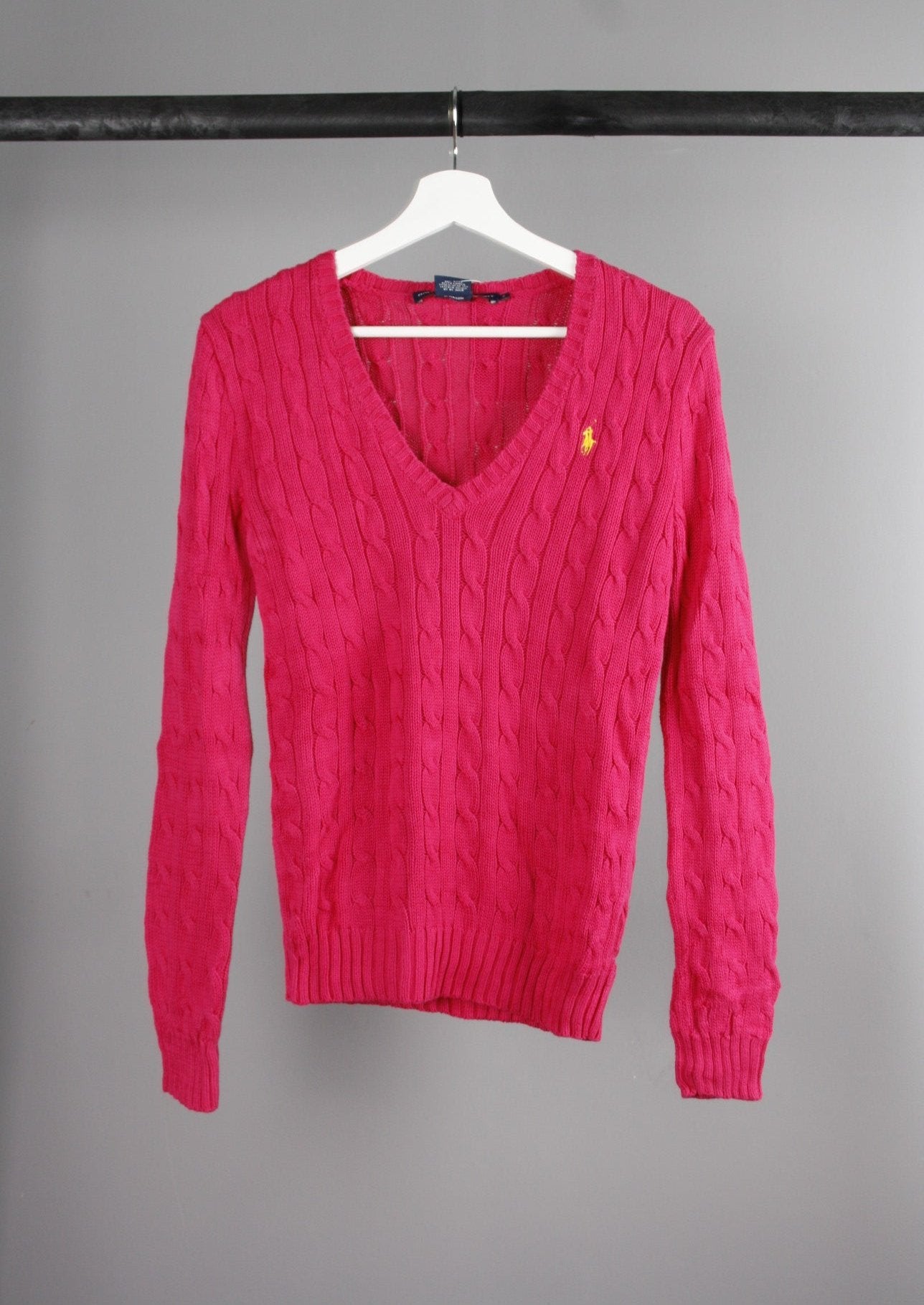 Voorkant van een Ralph Lauren Sport cable knit sweater in klassiek ontwerp met een geel paardje op de borst, gemaakt van hoogwaardige materialen voor comfort en stijl.