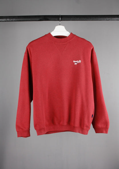 Voorkant van een rode Reebok sweater met een wit geborduurd logo links op de borst, voor een sportieve en casual uitstraling.