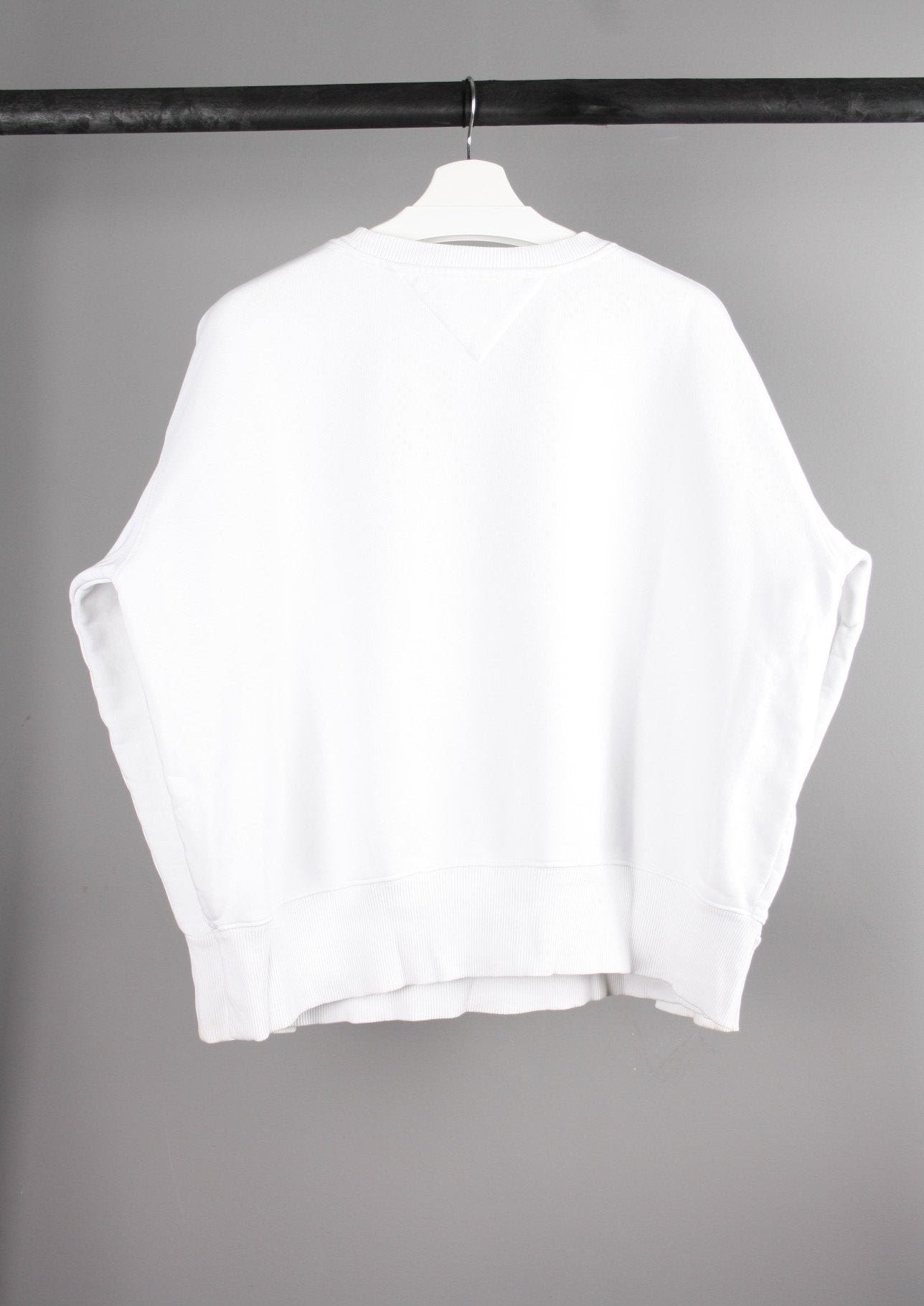 Achterkant van een witte Tommy Jeans sweater met een eenvoudige en stijlvolle afwerking, ideaal voor een casual en moderne look.